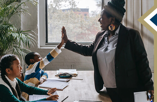 educational admin high fives a student across their desk