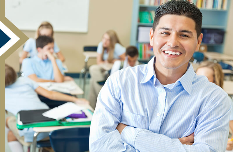 Hispanic male teacher leans on doorway with class in the background