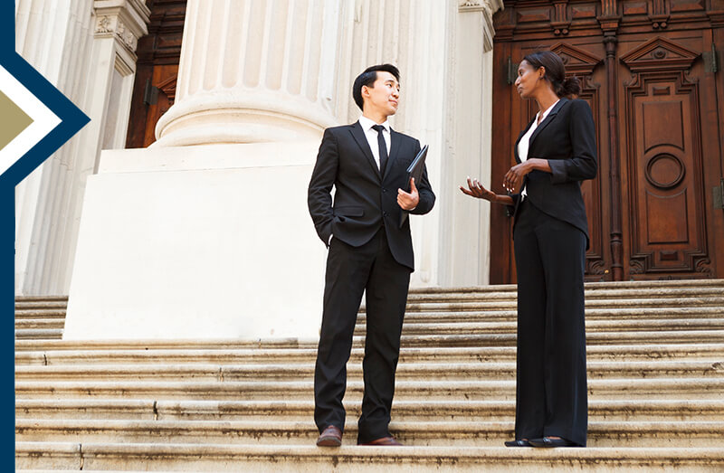 education policy professional meets with policymaker on the steps of a large courthouse