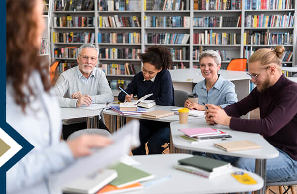 group of adult professionals in a library collaborating on a project - photo credit: Freepik