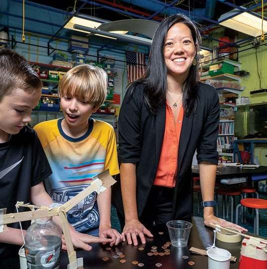 Stephanie Lin pictured with two students in a science lab. Photo used in Arlington Magazine courtesy of Skip Brown.