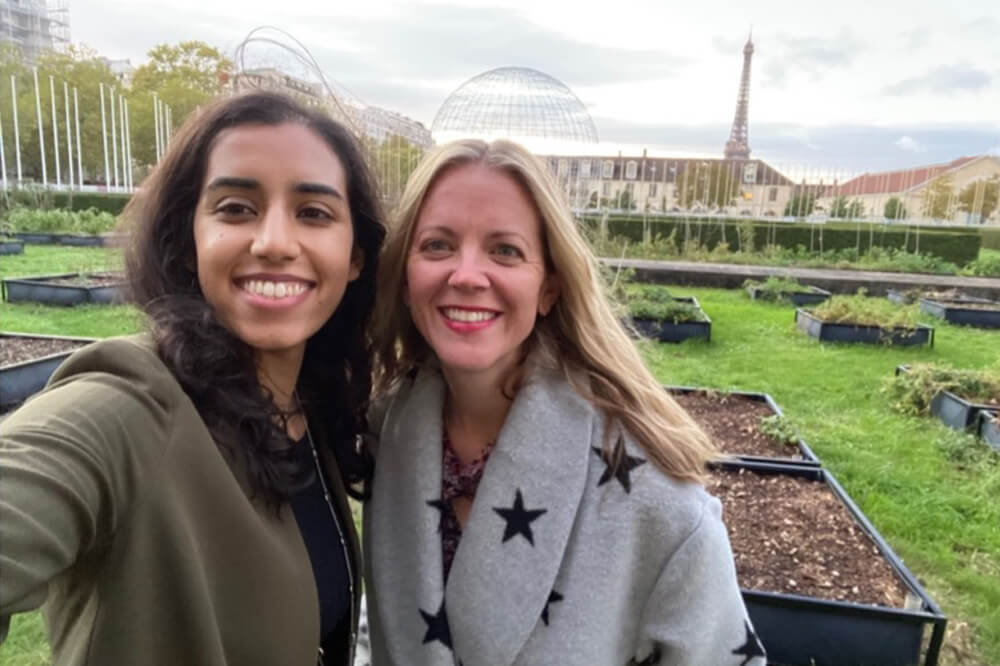 Dr. Engel and Maha Malik smile for selfie during the UNESCO/UNITWIN conference with Eiffel Tower in distance