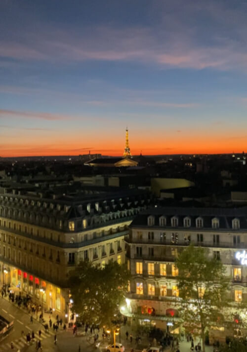 Eiffel tower when it was glittering in the distance at sunset from the top of Galleries Lafayette