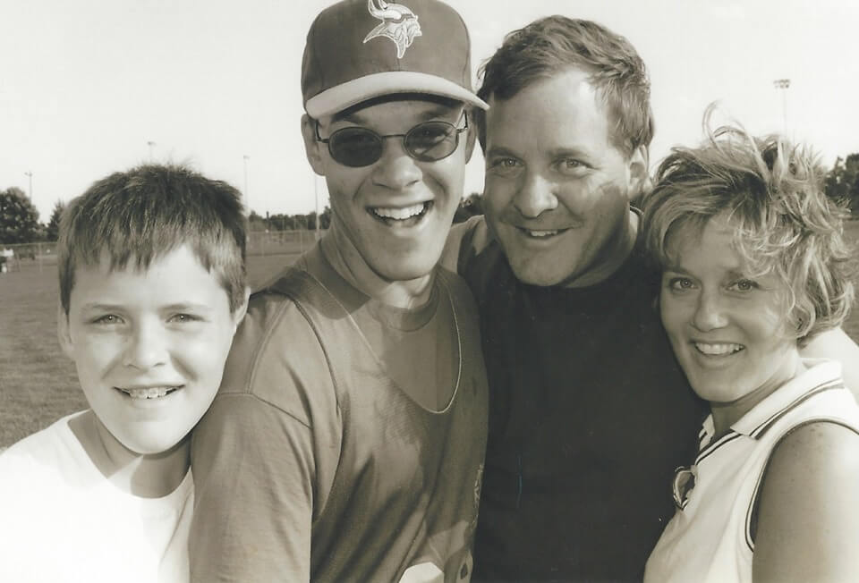black and white image of Kyle Hall with father, mother and brother