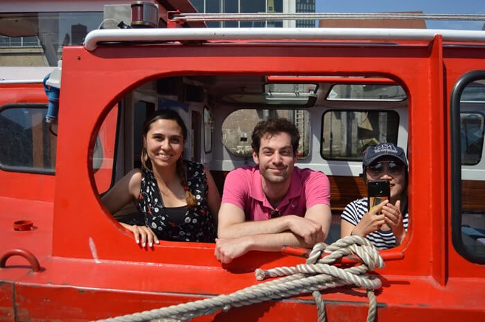 Kyle Hall smiles for camera out window of vehicle with friend before heading out on a tour