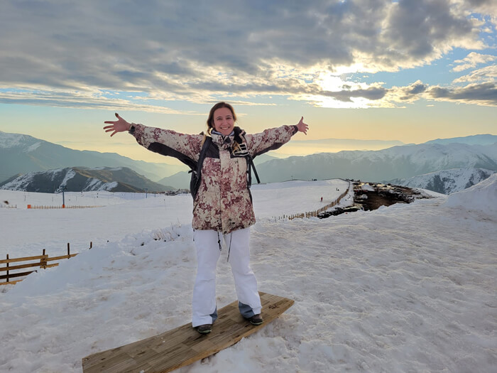 Caroline poses for a photo with arms outstretched on a Ski trip in the Andes