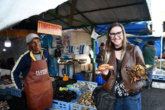Caroline poses for photo holding her purchases at the Valparaíso fish market