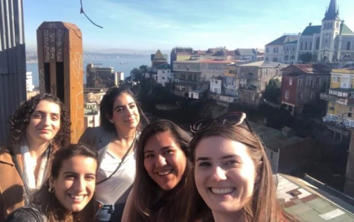 Maggie Montgomery poses for group photo with colleagues; Santiago city in the background