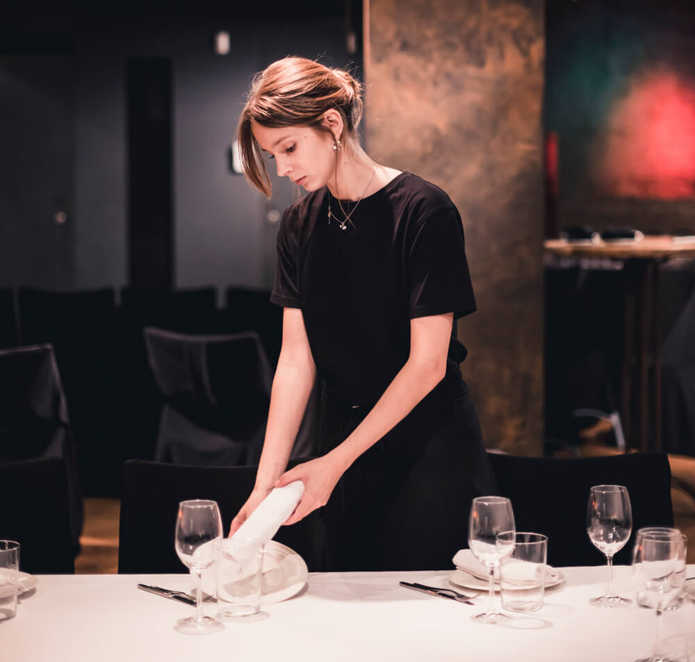 stock image of restaurant employee placing a table setting