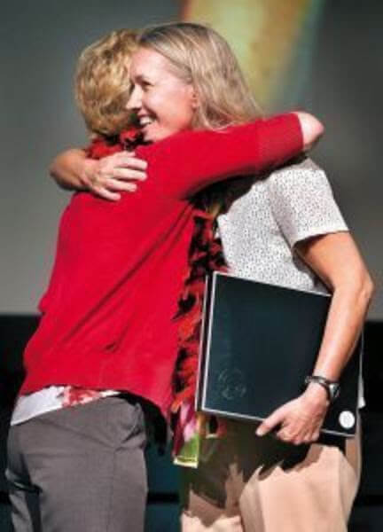 Marlies Mulkhuyse (right) gets a hug from Marla Demerly after Mulkhuyse is named Teacher of the Year