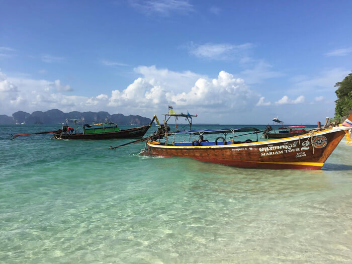 boats docked along beach in Krabi