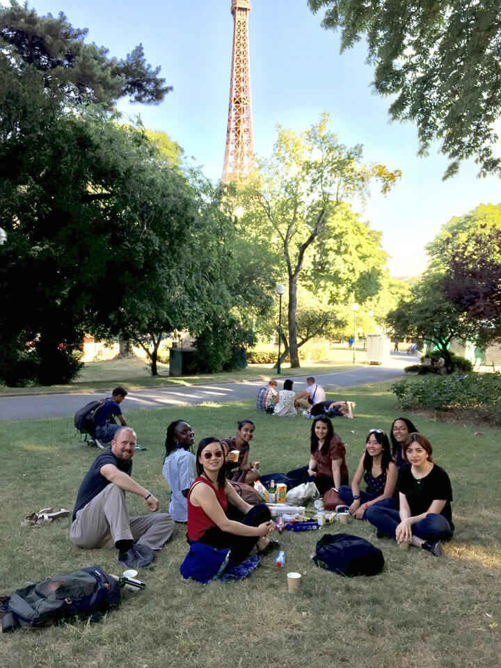 Dave and colleagues share a picnic in the park with the Eiffel Tower in the background