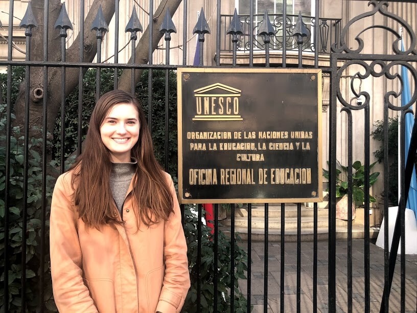 Maggie Montgomery poses in front of the gate into the OREALC/UNESCO office