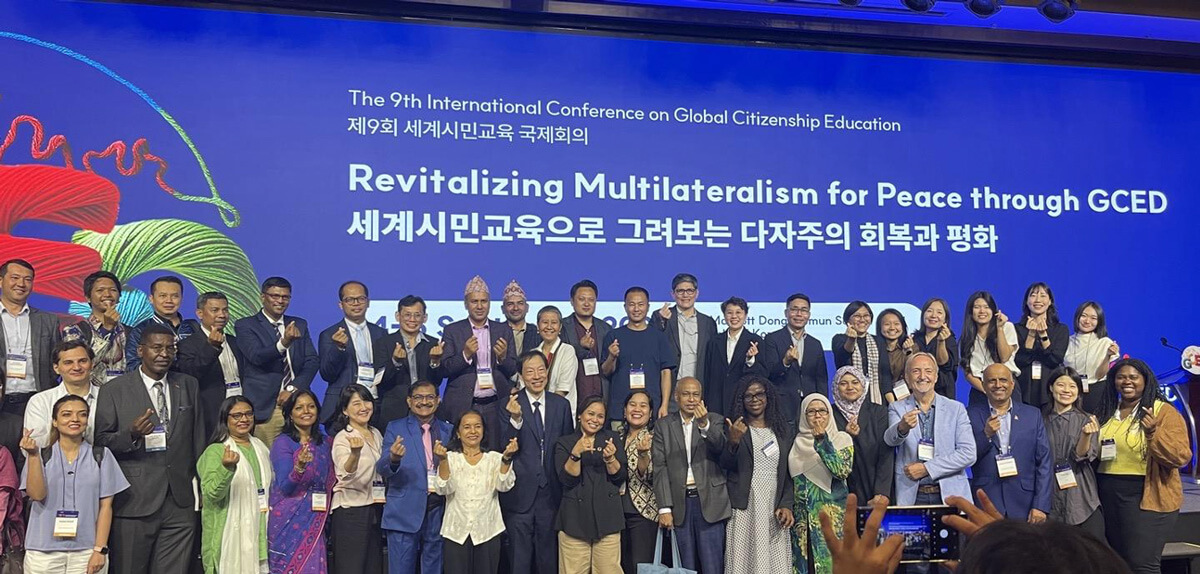 group photo of attendees at the 9th International Conference on Global Citizenship Education; Micha is included on the front row on the right