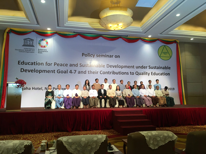 attendees of the "Policy Seminar on Education for Peace and Sustainable Development under Goal 4.7" pose for a group photo on stage