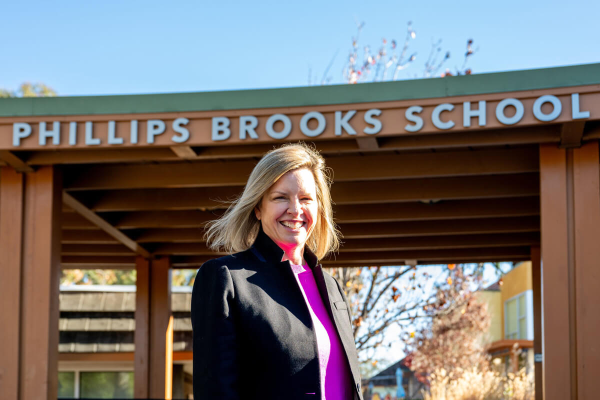 Jennifer Bohnen poses for a photo under the Phillips Brooks School sign