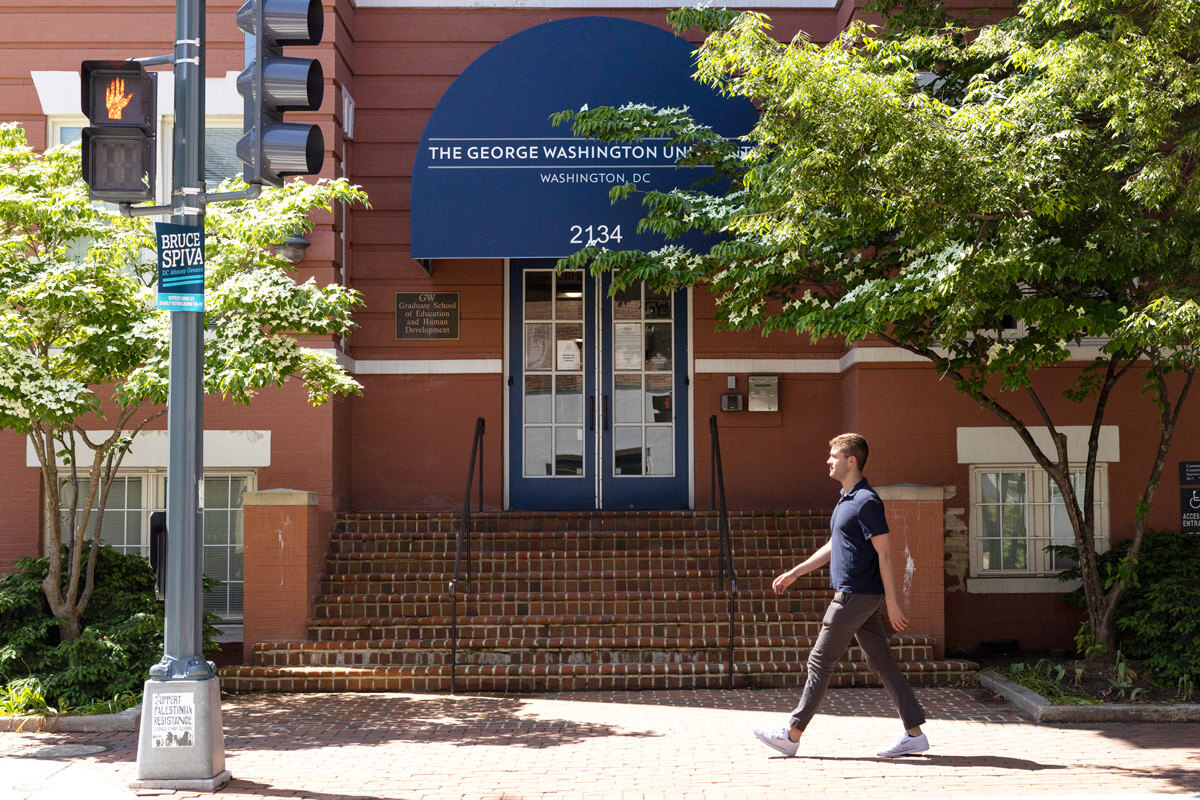 student walks toward GSEHD building