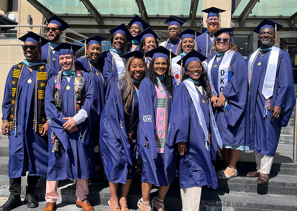 The first cohort of the GSEHD Educational Leadership and Administration program posed for photos their graduation attire in front of Gelman Library.