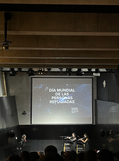 Stage at World Refugee Day Storytelling event featuring musicians and large screen