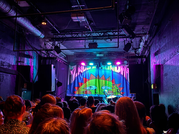 stage at small venue lit with purple lights