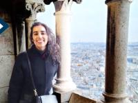 Maha Malik smiles for camera with ocean in the background in Paris during UNESCO fellowship
