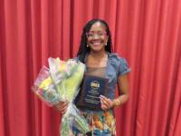 Dr. Maranda Ward smiles for photo with Rising Star award and bouquet of flowers