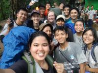 Stephanie poses in the center of a group of colleagues and Yangon University students while on a hike