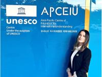 Tishkus poses in front of UNESCO APCEIU main entrance sign