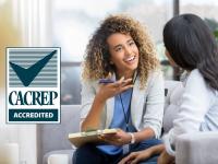 CACREP Accredited (photo of counselor speaking to client)