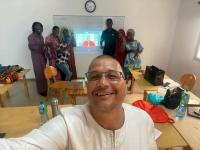 participants in Senegal pose for a group photo while one member takes a "selfie" of the group