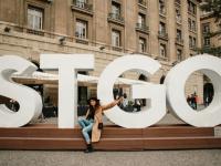 Renny poses for a photo in front of giant letters "STGO" at Plaza de Armas in Santiago’s Historic Center