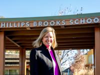 Jennifer Bohnen poses for a photo under the Phillips Brooks School sign