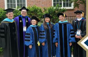 Program graduates and faculty in regalia pose for group photo at commencement 2022