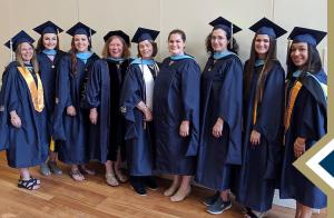 ISTS program graduates in regalia pose at graduation