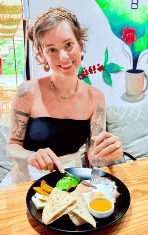 Lily smiling for photo while enjoying breakfast at Simbosis Cafe