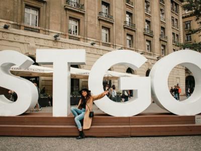 Renny poses for a photo in front of giant letters "STGO" at Plaza de Armas in Santiago’s Historic Center