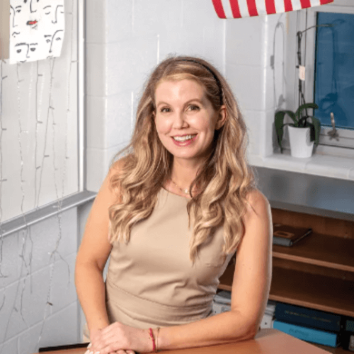 Jennifer Solove pictured in classroom behind desk. Photo used in MoCo 360 article courtesy of Skip Brown.