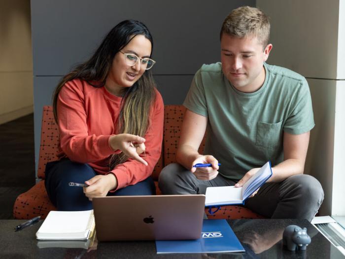 two GSEHD students studying for exam together point toward the laptop screen