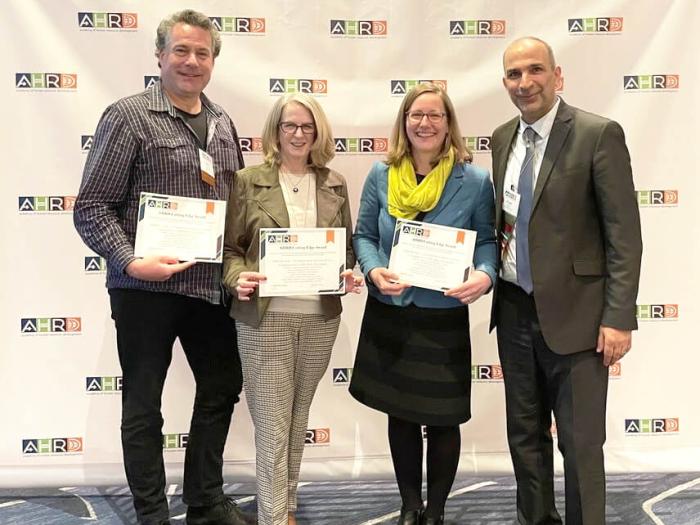 faculty pose for group photo after receiving award from AHRD