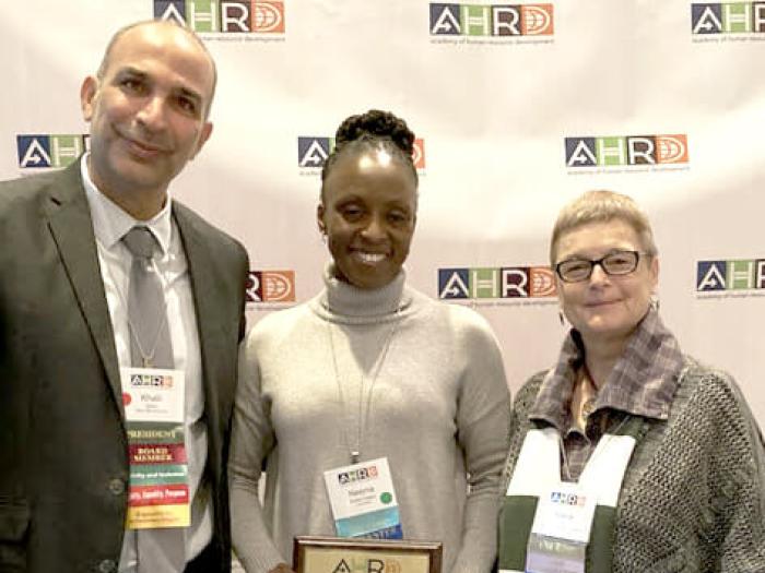 Neenia Barlatt-Higgins poses for photo after receiving award with Dr. Maria Cseh and award presenter