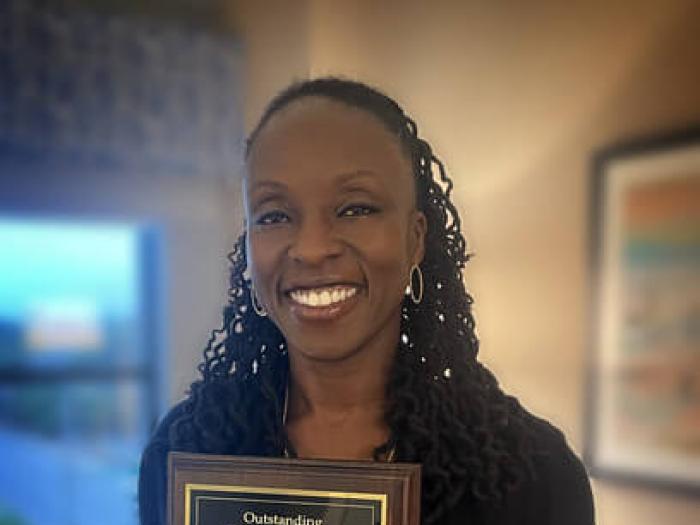 Dr. Neenia Barlatt-Higgins poses with award