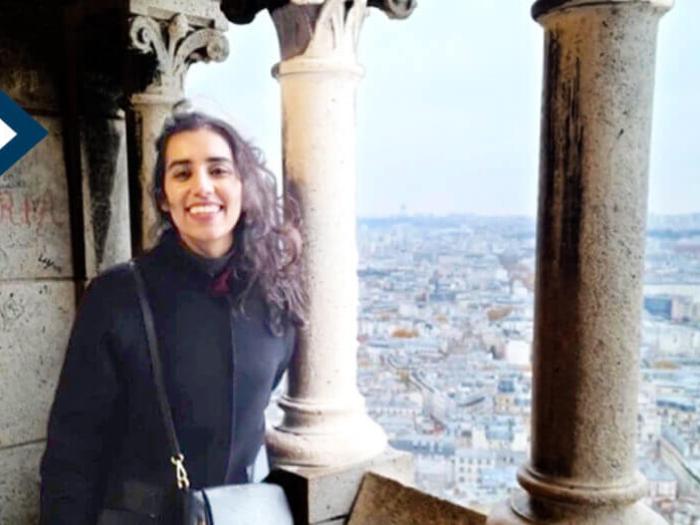 Maha Malik smiles for camera with ocean in the background in Paris during UNESCO fellowship
