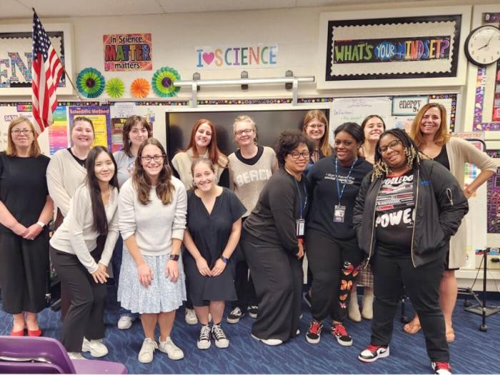 Principal Jamie Borg (far left) and Dr. Mary DeRaedt (far right) with GSEHD Elementary Ed Students