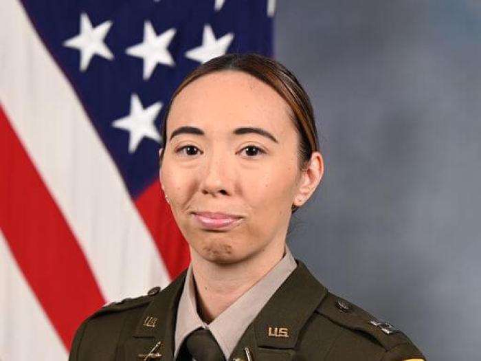 Capt. Catherine Grizzle headshot in military uniform and American flag in the background