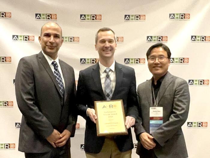 Dr. Oliver (Ozzie) Crocco (center) is awarded the Early Career Scholar Award