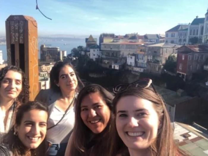 Maggie Montgomery poses for group photo with colleagues; Santiago city in the background