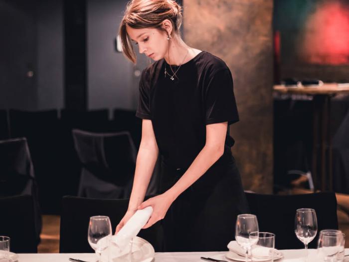stock image of restaurant employee placing a table setting