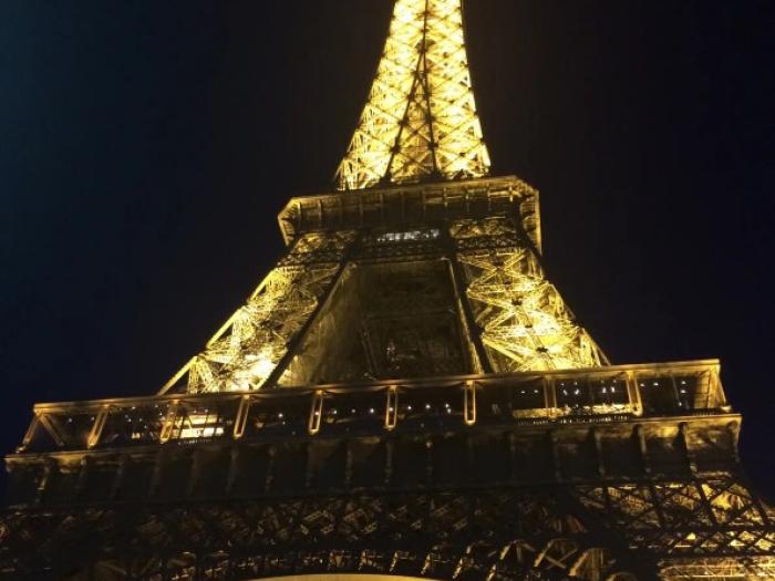 Eiffel Tower photographed from below at night while it's lit up