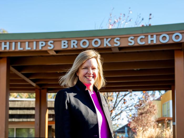 Jennifer Bohnen poses for a photo under the Phillips Brooks School sign