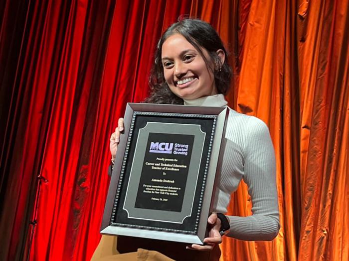 Amanda Deebrah proudly holds award